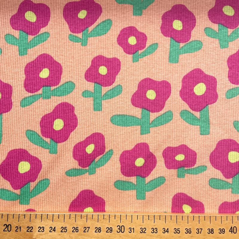 Tissu jersey côtelé fleurs fuschia fond pêche