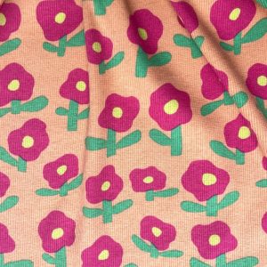 Tissu jersey côtelé fleurs fuschia fond pêche
